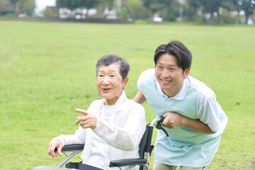 介護士と車椅子に乗る高齢者