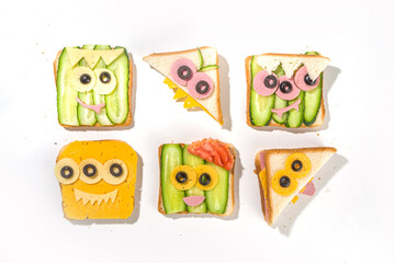 Various funny monster Halloween sandwiches. Set assortment creative breakfast snack toasts with cheese, Halloween kids party food, top view