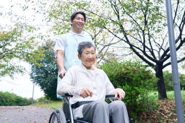 介護士と車椅子に乗る高齢者