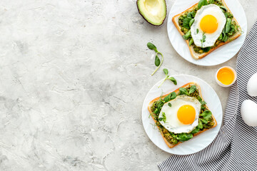 Open sandwich with avocado spinach cream and eggs. Top view