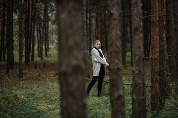 girl in black golf with a gray cape among the autumn forest