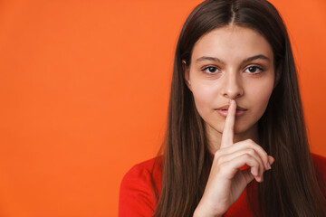 Naklejka premium Young white brunette woman showing silence gesture at camera