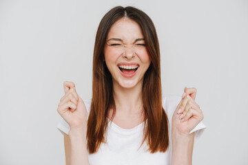 Young ginger woman in t-shirt laughing while holding clenched her fists