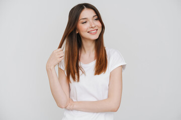 Fototapeta premium Young ginger woman holding her hair and looking aside