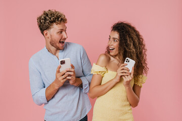 Young couple expressing surprise while using mobile phones