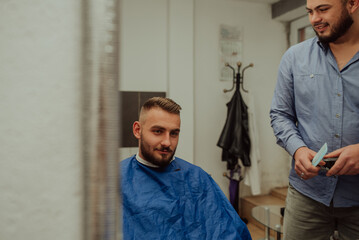 Obraz premium Young Man in Barbershop Hair Care Service Concept. Selective focus