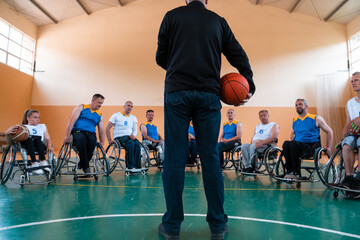 Fototapeta na wymiar selector I explain new tactics to basketball players in wheelchairs, players sit in wheelchairs listening to the selector