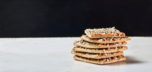 Crisp bread with seeds. Crunchy crispbread on a wooden background. Healthy snack: cereal crunchy multigrain cereal flax seed, sunflower seeds protein bread bar