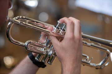 a small jazz band showing close ups of hands on brass instruments