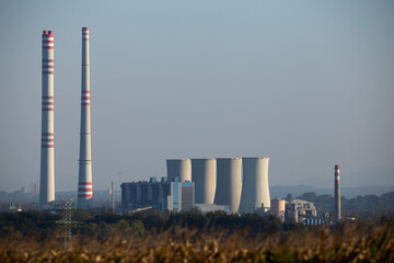 Black coal-fired power plant seen from a distance. No smoke coming out from the chimneys. Photo taken during the day under natural lighting conditions.