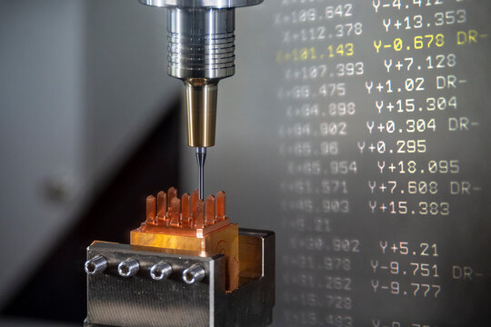 The abstract scene CNC milling machine cutting the  electrode parts with G-code data background.