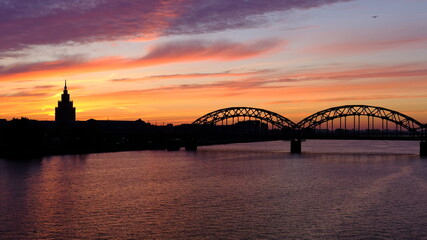 Naklejka premium Railway bridge in Riga against the background of dawn in autumn.
