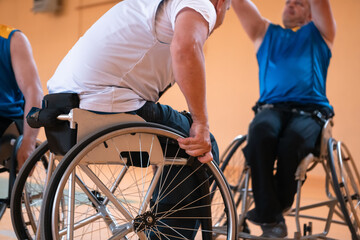 Fototapeta na wymiar Close up photo of wheelchairs and handicapped war veterans playing basketball on the court