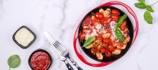 Gnocchi with tomatoes, red sauce, cheese and basil leaves