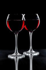 Red wine in a glass, on a black background.
