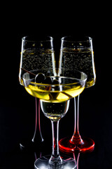White wine in a glass, on a black background.