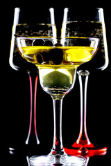 White wine in a glass, on a black background.