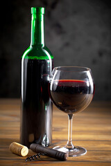 Wine in a glass, on an old background, with a bunch of grapes. Natural product.