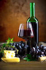 Wine in a glass, on an old background, with a bunch of grapes. Natural product.