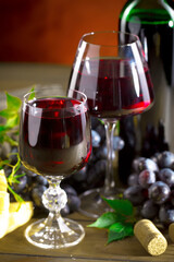 Wine in a glass, on an old background, with a bunch of grapes. Natural product.
