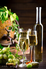 Wine glass with bottle and grapes on an old background.