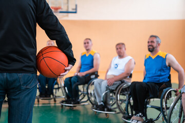 selector I explain new tactics to basketball players in wheelchairs, players sit in wheelchairs listening to the selector