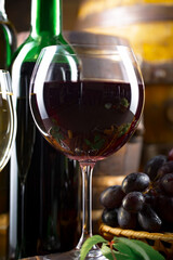 Wine glass with bottle and grapes on an old background.