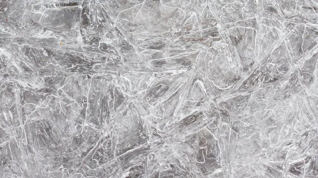 cracked ice texture on the surface, slow motion close-up, natural clean background. Frozen water texture