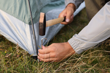 Man setting up camping tent outdoors, closeup © New Africa