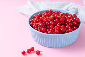 Fresh red currant in wooden bowl on dark table