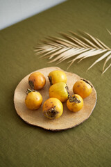 Fresh juicy sweet persimmons on an unusual clay plate. View from above.
