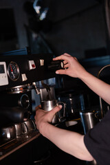 Process of preparing milk foam for cappuccino or latte, heating and whipping. Barista steaming milk in the pitcher