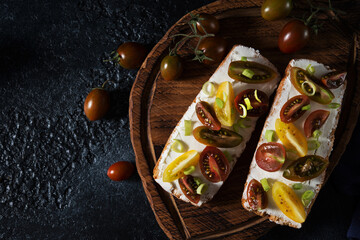 Fototapeta na wymiar Bruschetta with tomatoes and olive oil on a wooden board - traditional Italian, Spanish snack, selective focus