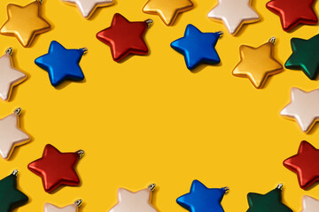 Creative Christmas vibrant colour star shaped baubles decoration pattern on yellow paper...