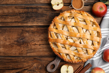 Delicious traditional apple pie on wooden table, flat lay. Space for text