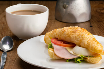 View of delicious ham cheese croissants and hot milk coffee for breakfast.