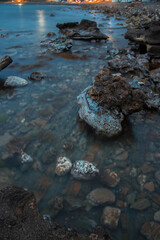 Fototapeta na wymiar beach of rocks at the sunset 