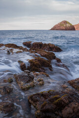 beach of rocks and the coast of the ocean at the sunset