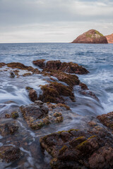 Fototapeta na wymiar beach of rocks and the coast of the ocean at the sunset