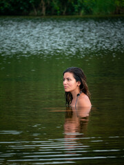 Latin Woman with a Suspicious Look is Swimming in the San Salvador River Surrounded by Vegetation in Palomino, La Guajira, Colombia