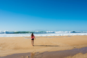 Fototapeta na wymiar pretty little girl barefoot by the turquoise ocean