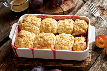 Plum cobbler on a wooden background.