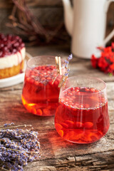 lingonberry and lavender tea in a glass glass. Side view. Wooden background.
