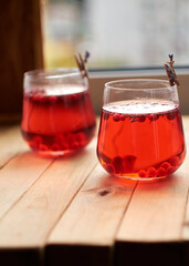 lingonberry and lavender tea in a glass glass. Side view. Wooden background.