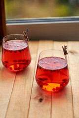 lingonberry and lavender tea in a glass glass. Side view. Wooden background.
