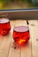 lingonberry and lavender tea in a glass glass. Side view. Wooden background.