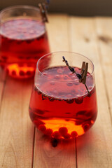 lingonberry and lavender tea in a glass glass. Side view. Wooden background.