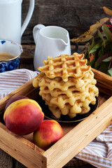 Belgian waffles with nectarine. Side view, wooden background. Rustic.