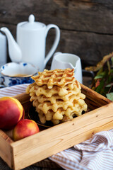 Belgian waffles with nectarine. Side view, wooden background. Rustic.