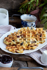Belgian waffles blueberries. Side view, wooden background. Rustic.